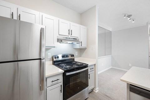 a kitchen with white cabinets and stainless steel appliances